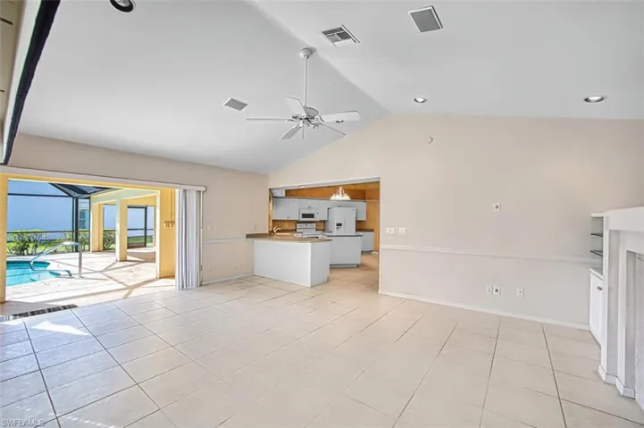 Unfurnished living room with vaulted ceiling, light tile patterned flooring, ceiling fan, recessed lighting, and a sunroom