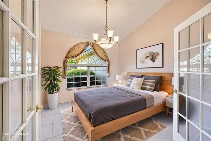 *VIRTUALLY STAGED* Bedroom with tile patterned flooring, ornamental molding, a chandelier, and vaulted ceiling