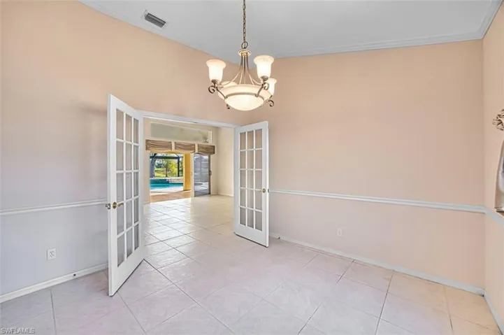 Den featuring french doors, a chandelier, light tile patterned floors, and crown molding