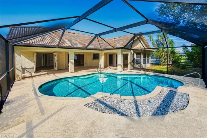 Swimming pool with glass enclosure, a sunroom, and a patio