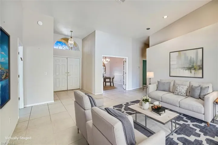 *VIRTUALLY STAGED* Living room featuring a chandelier, light tile patterned flooring, a high ceiling, and recessed lighting