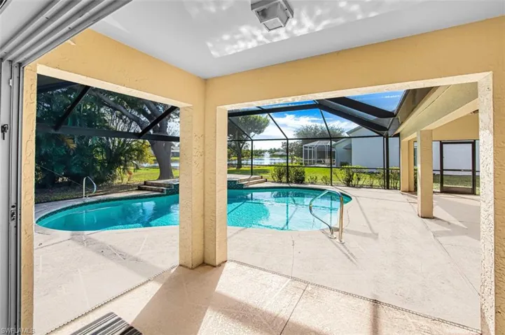 Swimming pool featuring a patio, a sunroom, and glass enclosure