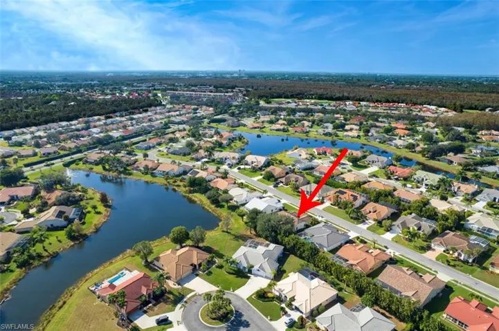 Aerial view of property and surrounding area featuring a large body of water and nearby suburban area