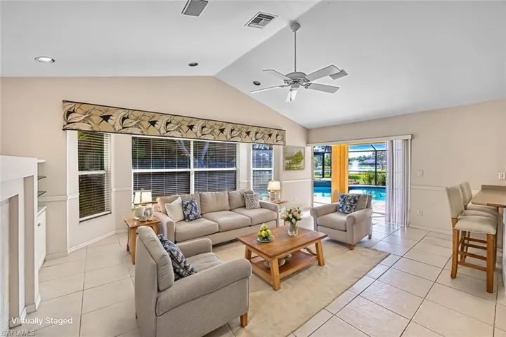 *VIRTUALLY STAGED* Living area featuring light tile patterned flooring, a ceiling fan, and high vaulted ceiling