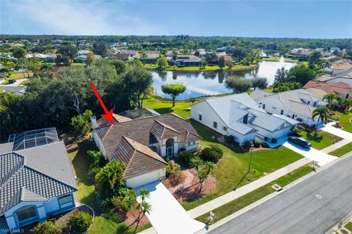 Aerial perspective of suburban area featuring a nearby body of water