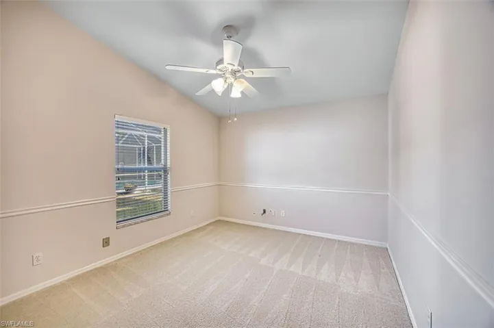 Bedroom featuring light carpet, vaulted ceiling, and a ceiling fan