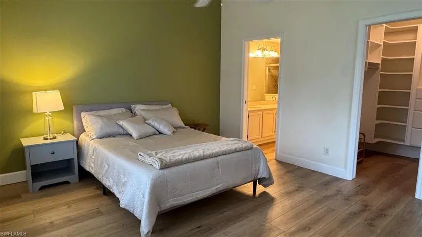 Master Bedroom with a walk in closet, ensuite bathroom, a closet, and hardwood / wood-style floors