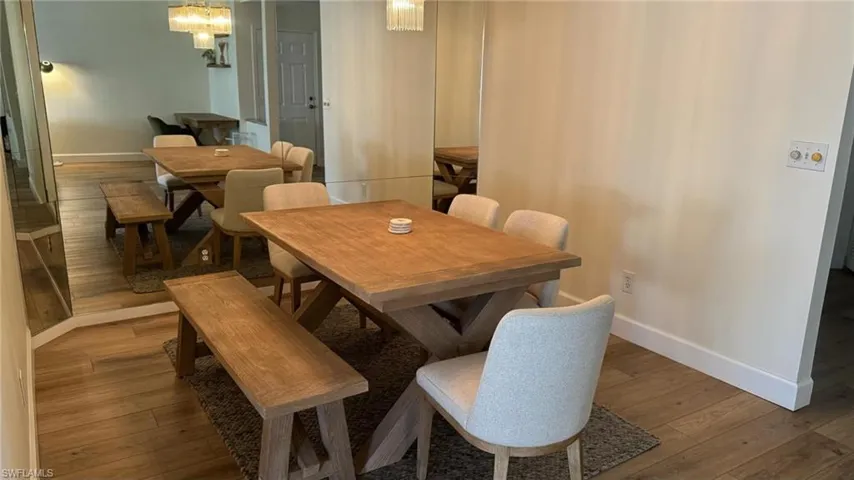 Dining area featuring light wood-type flooring and a notable chandelier