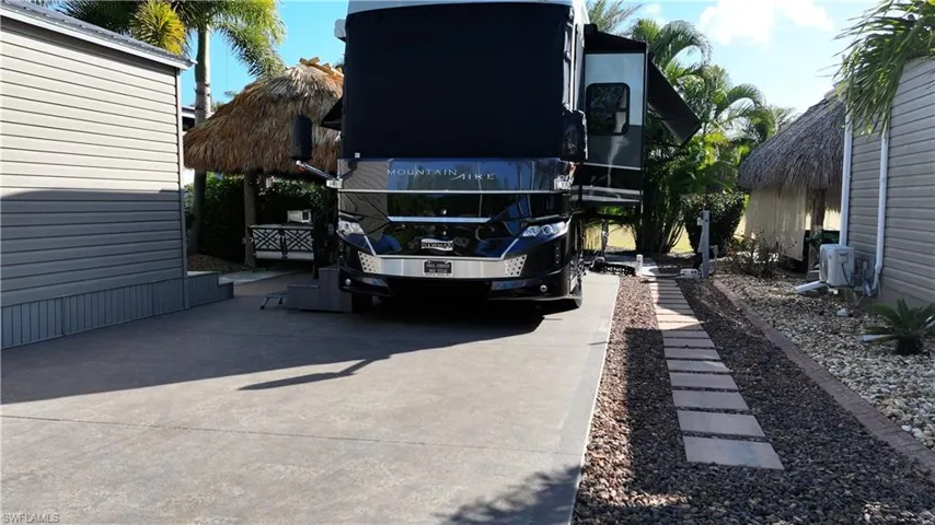 View of parking featuring concrete driveway