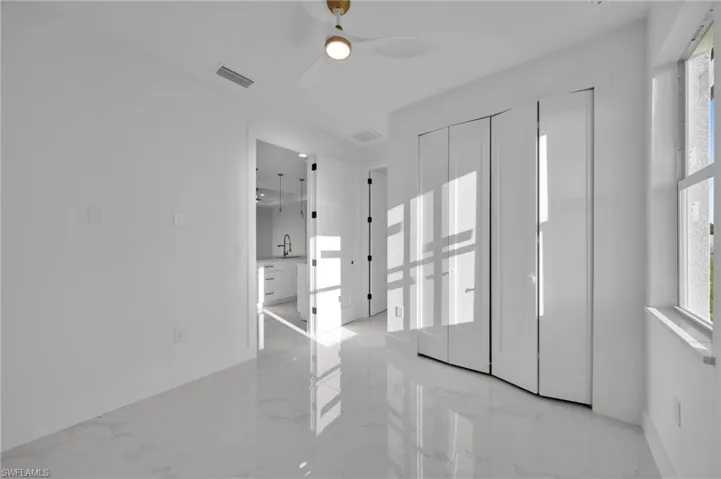Spare room featuring light marble finish flooring and a ceiling fan