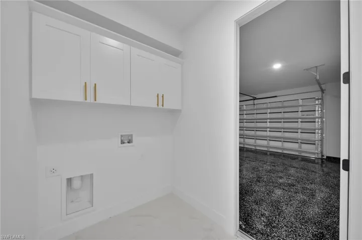 Laundry room with a garage, hookup for a washing machine, light marble finish floors, cabinet space, and recessed lighting