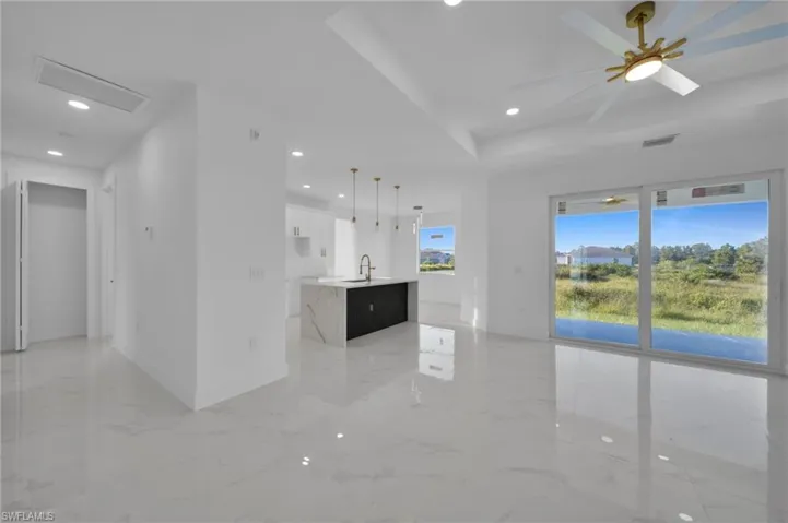 Unfurnished living room with recessed lighting, a ceiling fan, and light marble finish floors