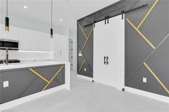 Kitchen with stainless steel microwave, light marble finish flooring, white cabinetry, recessed lighting, and modern cabinets