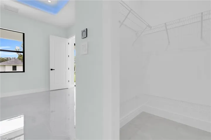 Walk in closet with light marble finish flooring