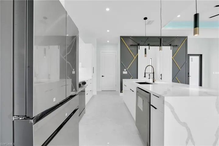 Kitchen featuring modern cabinets, stainless steel dishwasher, white cabinets, recessed lighting, and hanging light fixtures