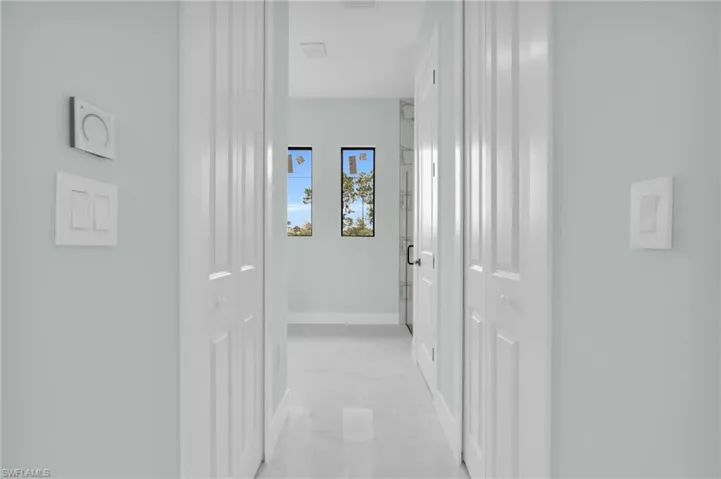 Hall featuring light marble finish flooring and baseboards