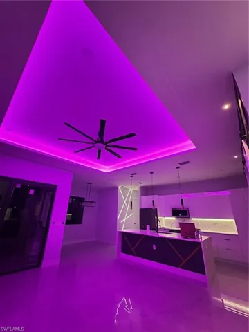 Bar area with fridge, hanging light fixtures, and ceiling fan