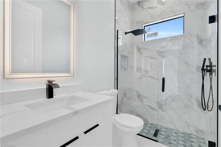 Full bathroom featuring vanity and a marble finish shower