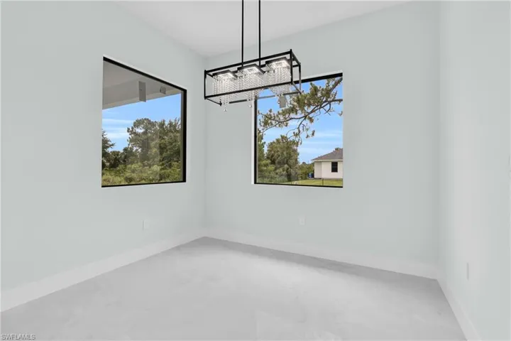 Unfurnished dining area featuring marble finish flooring, a chandelier, and plenty of natural light