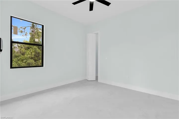 Spare room featuring ceiling fan and baseboards