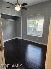 Unfurnished bedroom featuring ceiling fan, dark hardwood / wood-style floors, and a closet