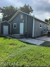 Back of property with a yard and a storage unit