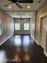 Unfurnished room featuring ceiling fan and dark hardwood / wood-style flooring