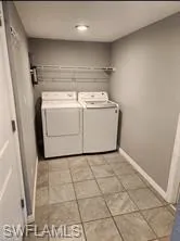 Laundry room with washer and dryer and light tile patterned floors