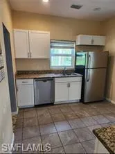 Kitchen with sink, white cabinets, and appliances with stainless steel finishes