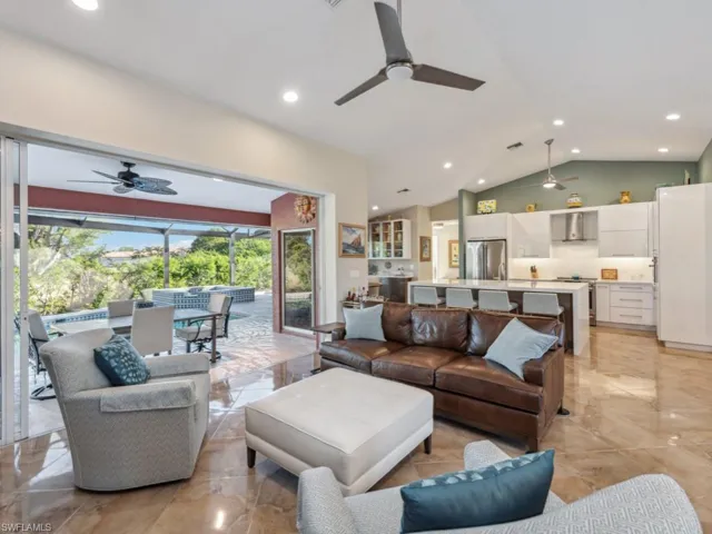 Living room featuring ceiling fan and vaulted ceiling