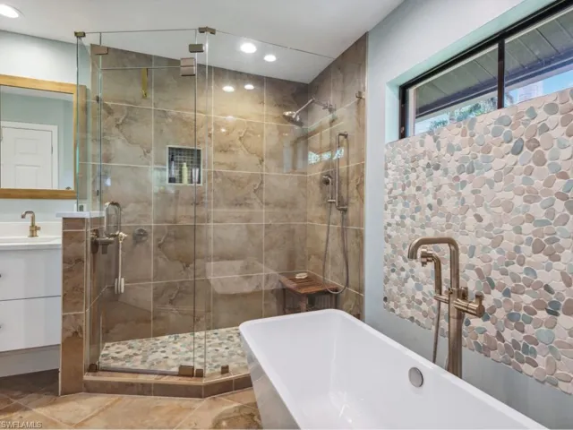 Bathroom with plus walk in shower, vanity, and tile patterned flooring