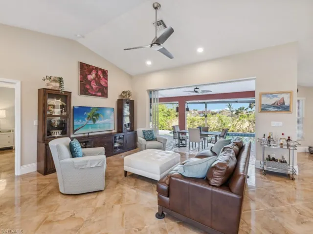 Living room with ceiling fan and lofted ceiling