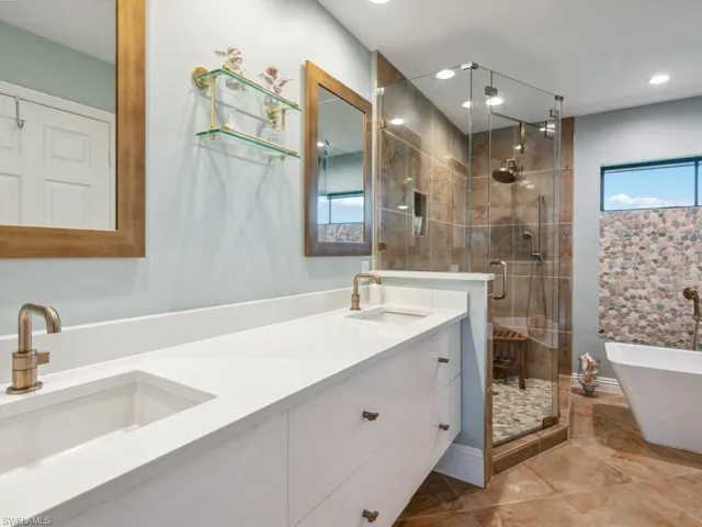 Bathroom featuring vanity and independent shower and bath