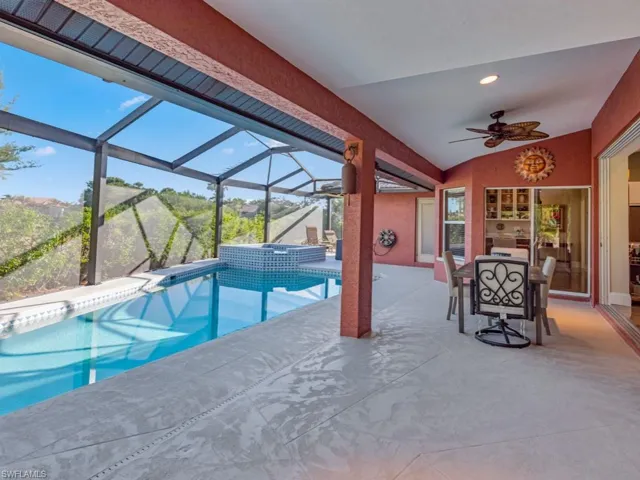 View of swimming pool with a mountain view, glass enclosure, an in ground hot tub, and ceiling fan