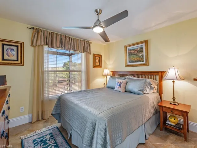 Bedroom with ceiling fan and light tile patterned flooring