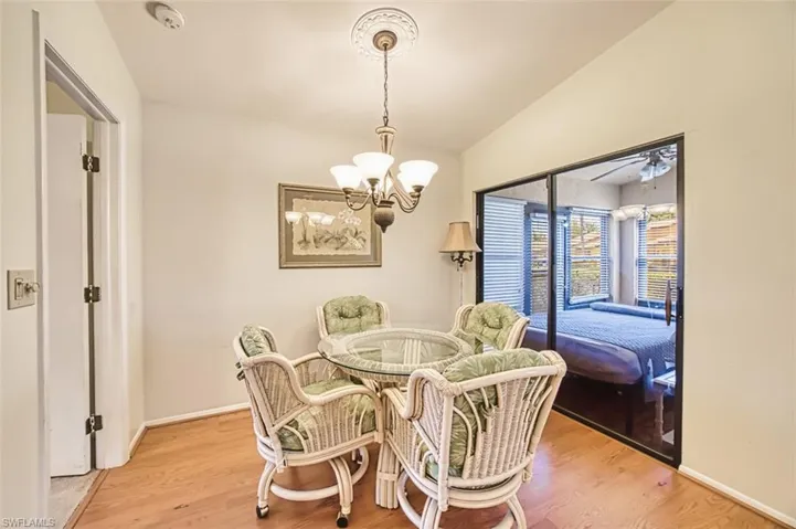 Dining room with light wood-style flooring, lofted ceiling,