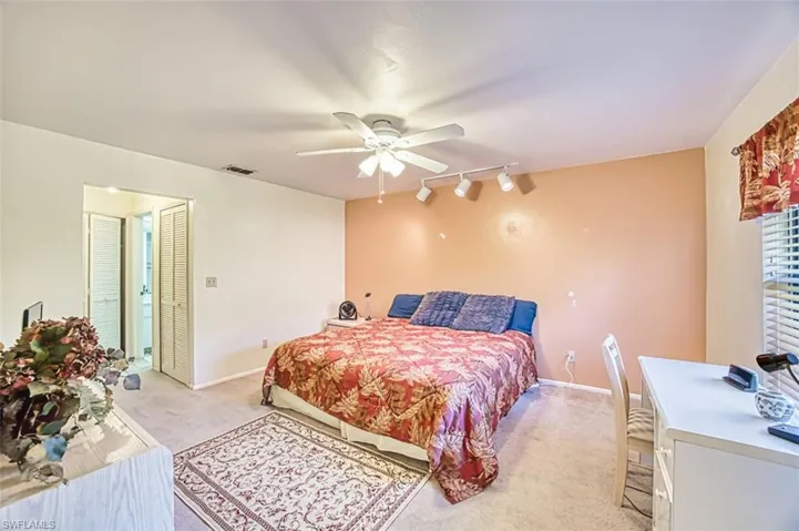 Bedroom with track lighting, light carpet, and ceiling fan
