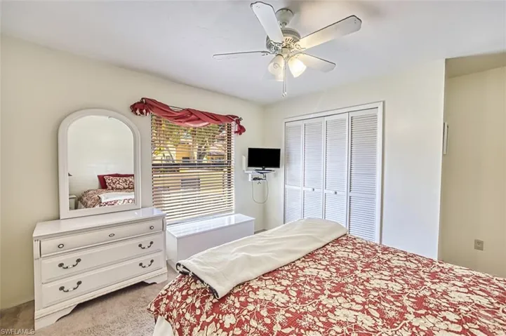 Bedroom featuring light colored carpet, ceiling fan, and a closet