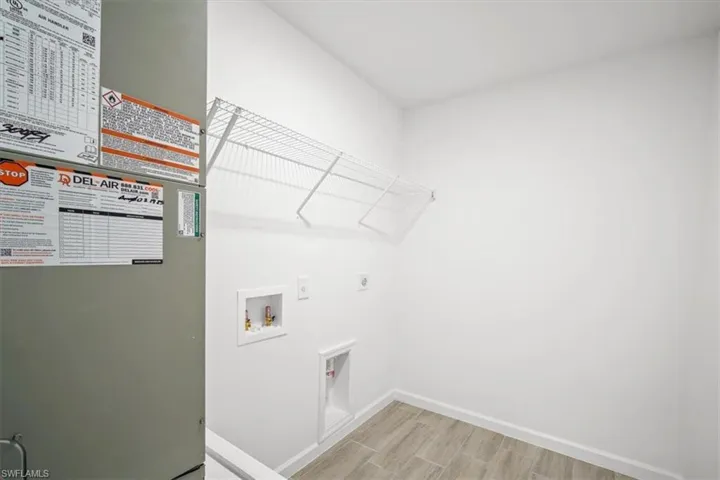 Laundry room with heating unit, wood tiled floors, washer hookup, and electric dryer hookup