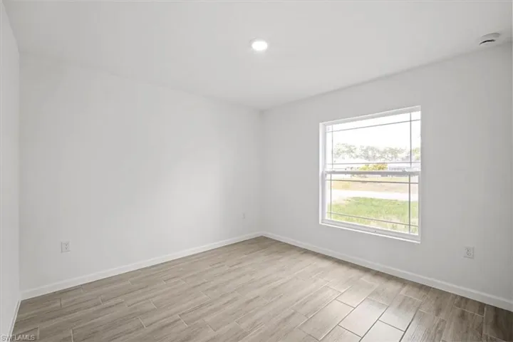 Unfurnished room with wood tiled floors and baseboards