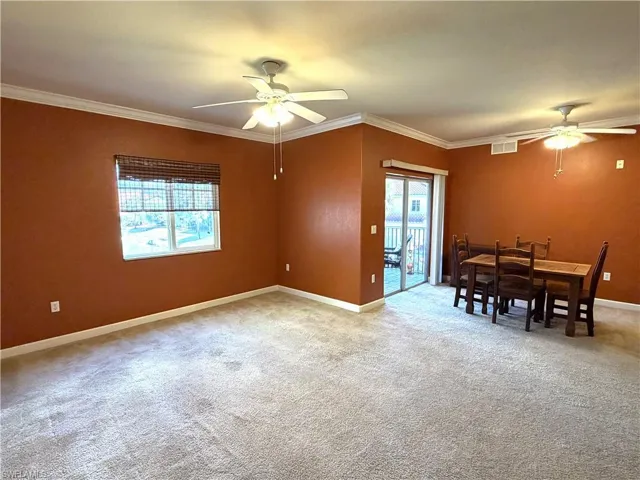 Carpet, ceiling fan, and crown molding