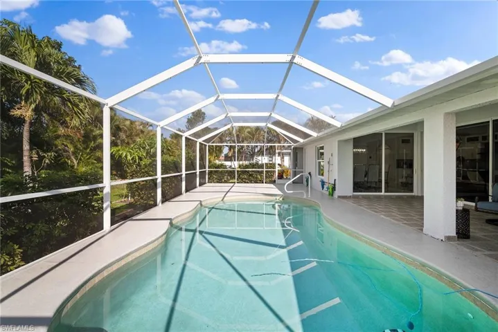 Swimming pool featuring a patio area and glass enclosure