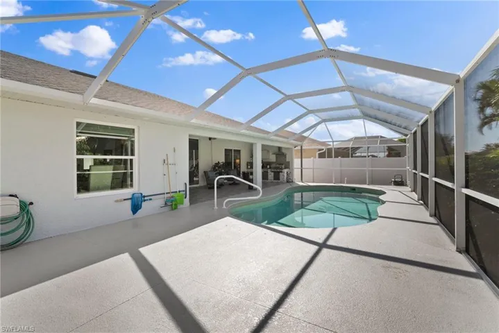 View of pool with a patio and glass enclosure