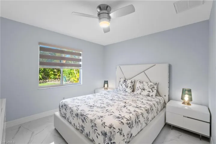 Bedroom featuring light marble finish floors and ceiling fan