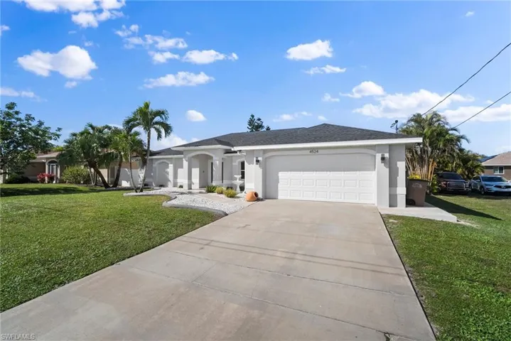 Ranch-style house featuring stucco siding, an attached garage, and a front lawn