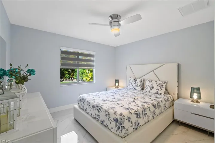 Bedroom featuring light marble finish flooring and ceiling fan