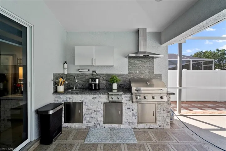 View of patio featuring exterior kitchen and a lanai