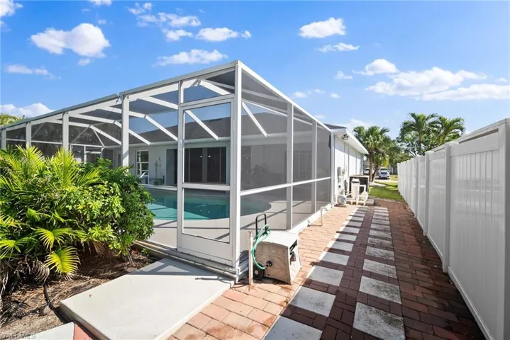 Back of property featuring an outdoor pool, a patio, and a lanai
