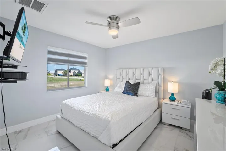 Bedroom with light marble finish flooring and ceiling fan
