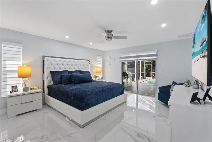 Bedroom featuring access to outside, light marble finish floors, recessed lighting, and a ceiling fan